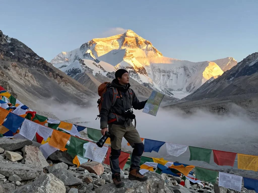 Everest Base Camp Trek with Helicopter Return traveler at sunrise, showcasing mountain backdrop and adventure.